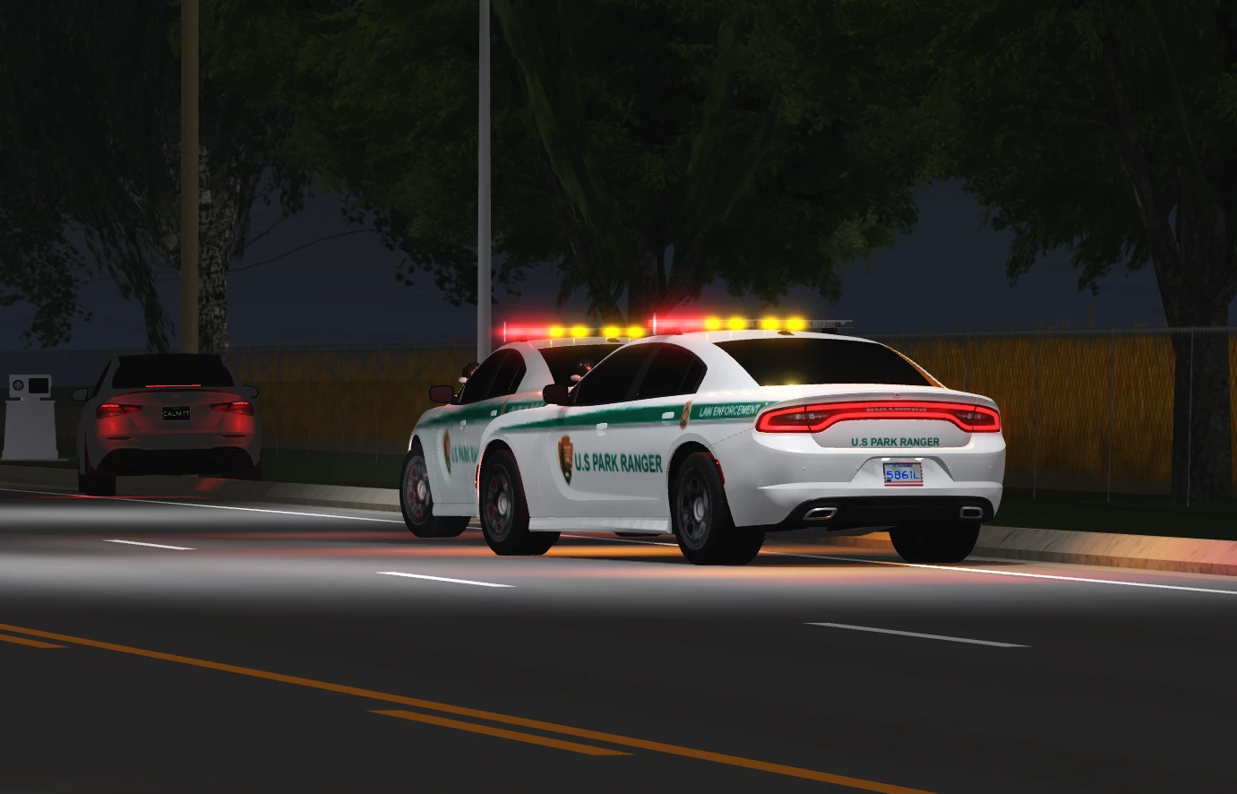 Two U.S. Park Ranger cruisers pulled over with their lights on at night.
